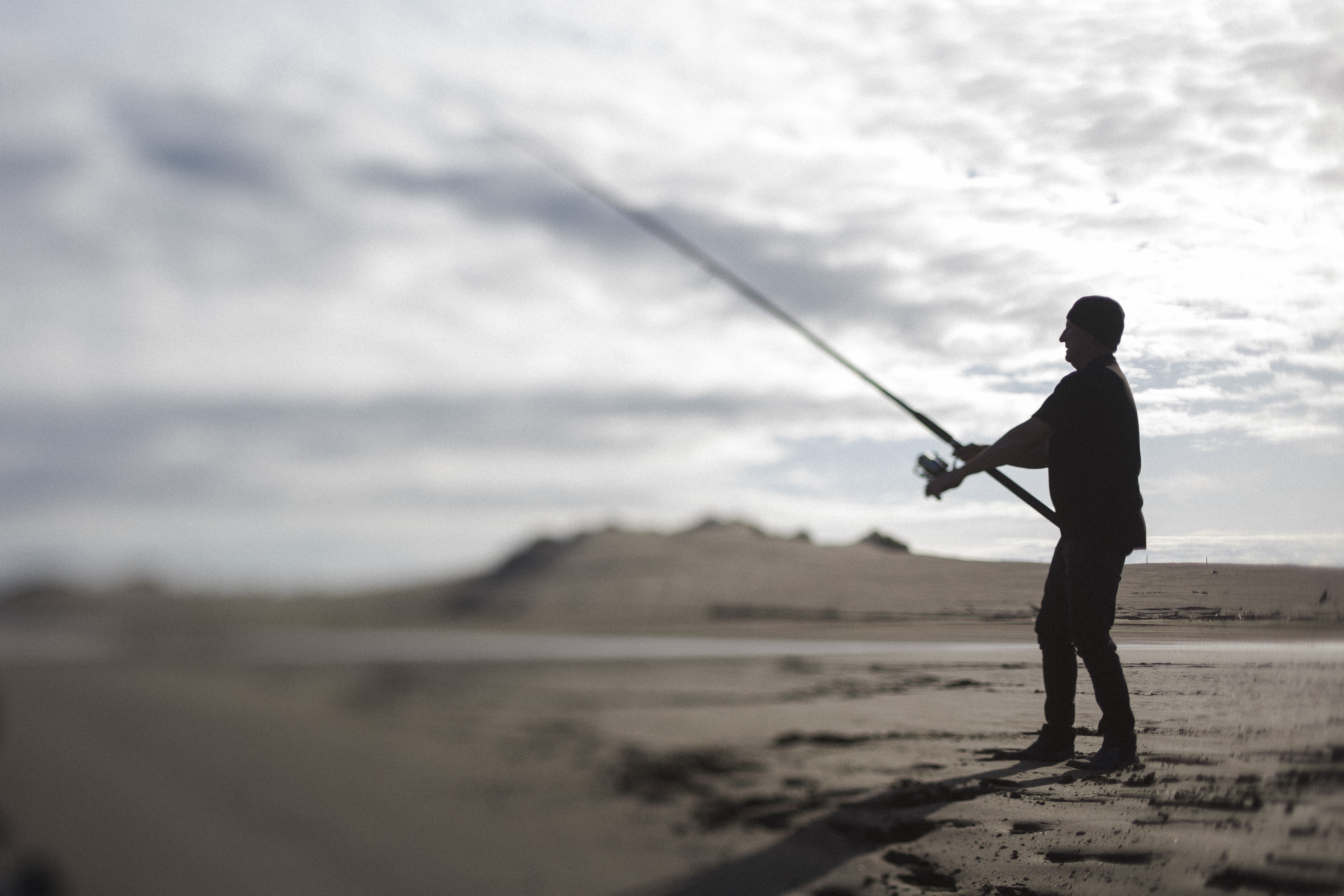 Man standing on a beach with a fishing line