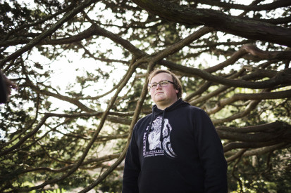 Man wearing glasses standing underneath tree