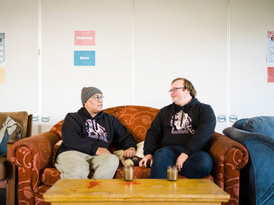Two men sitting on a couch chatting