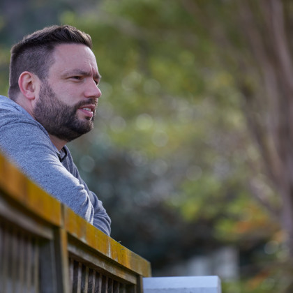 Man looking over a backyard fence